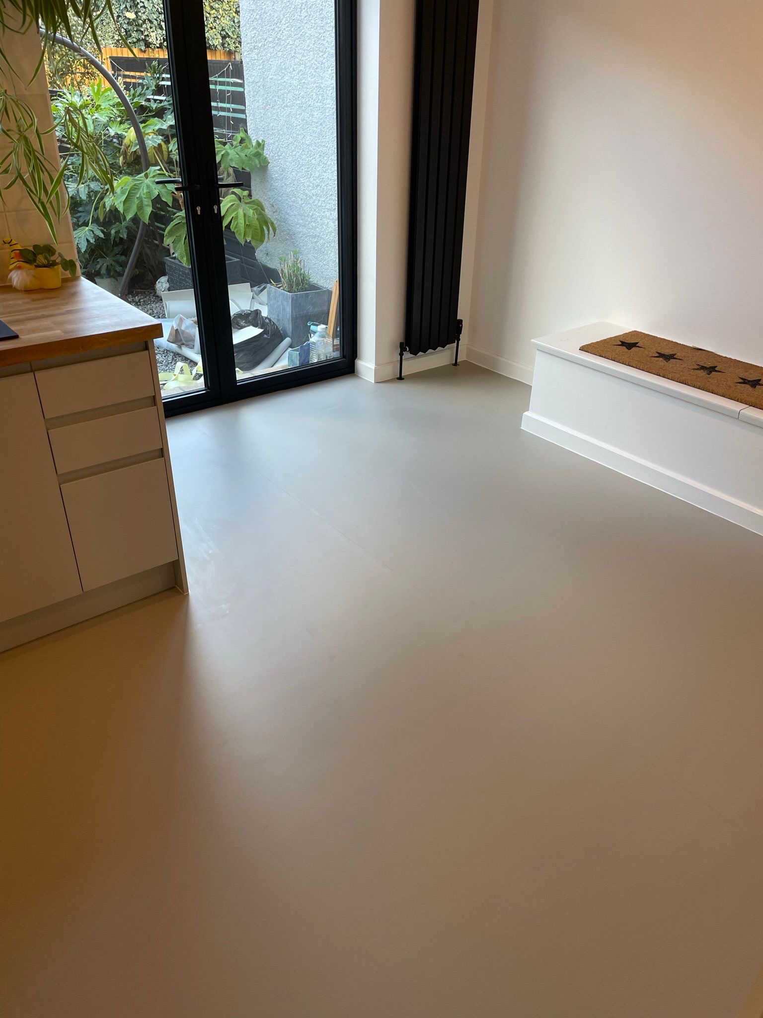 A recently fitted floor by CountryLife Flooring — smooth light-grey vinyl in a bright modern kitchen-diner with garden view.