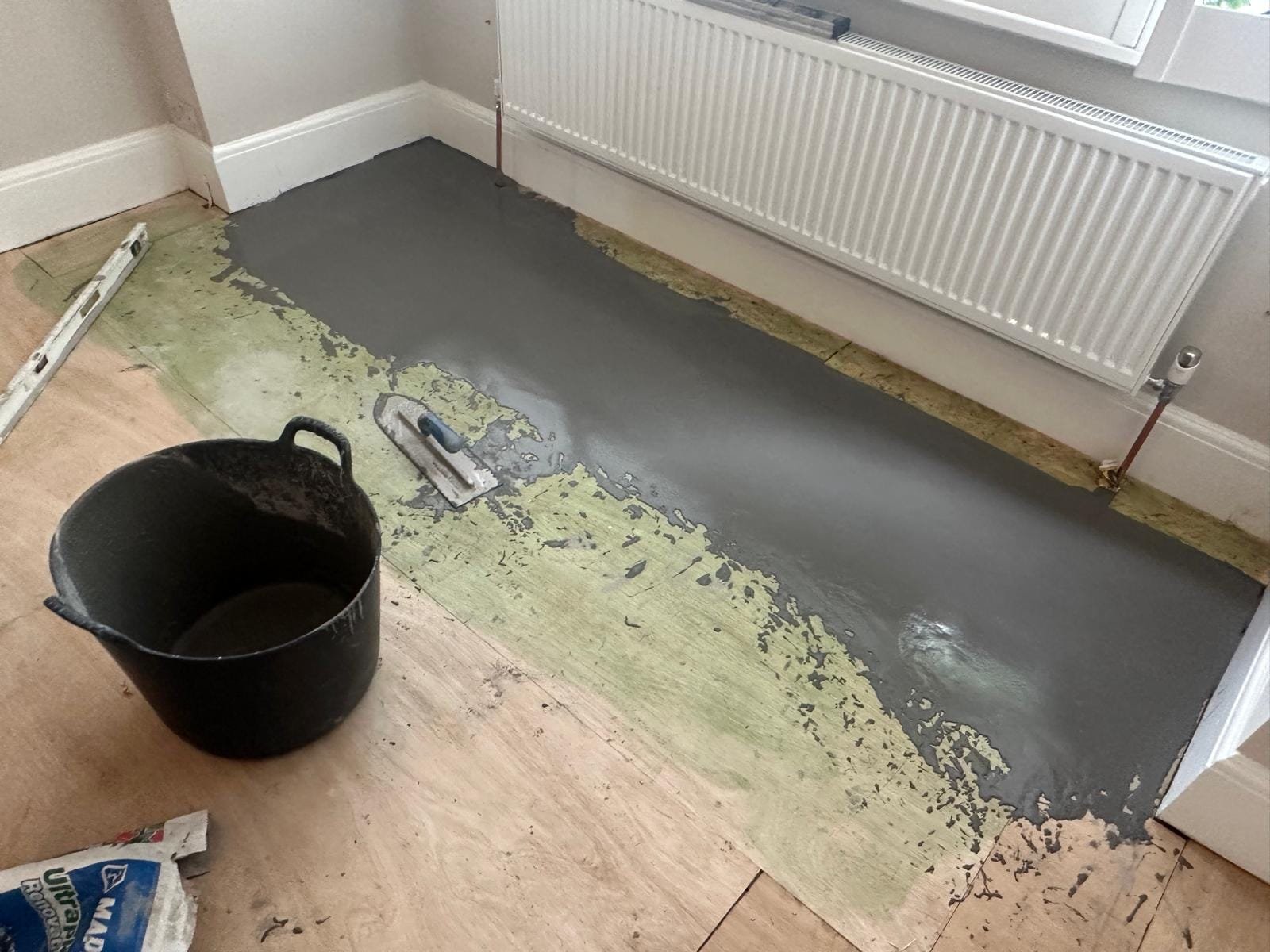 Feather-edged and latexed subfloor prepared before laminate fitting