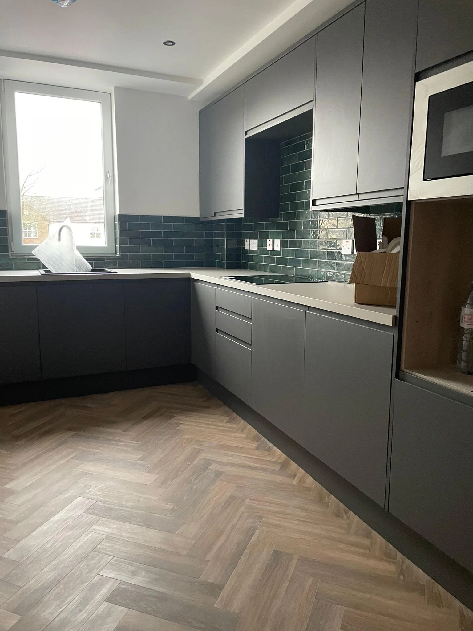 Karndean herringbone wood-effect LVT flooring fitted in a modern grey kitchen